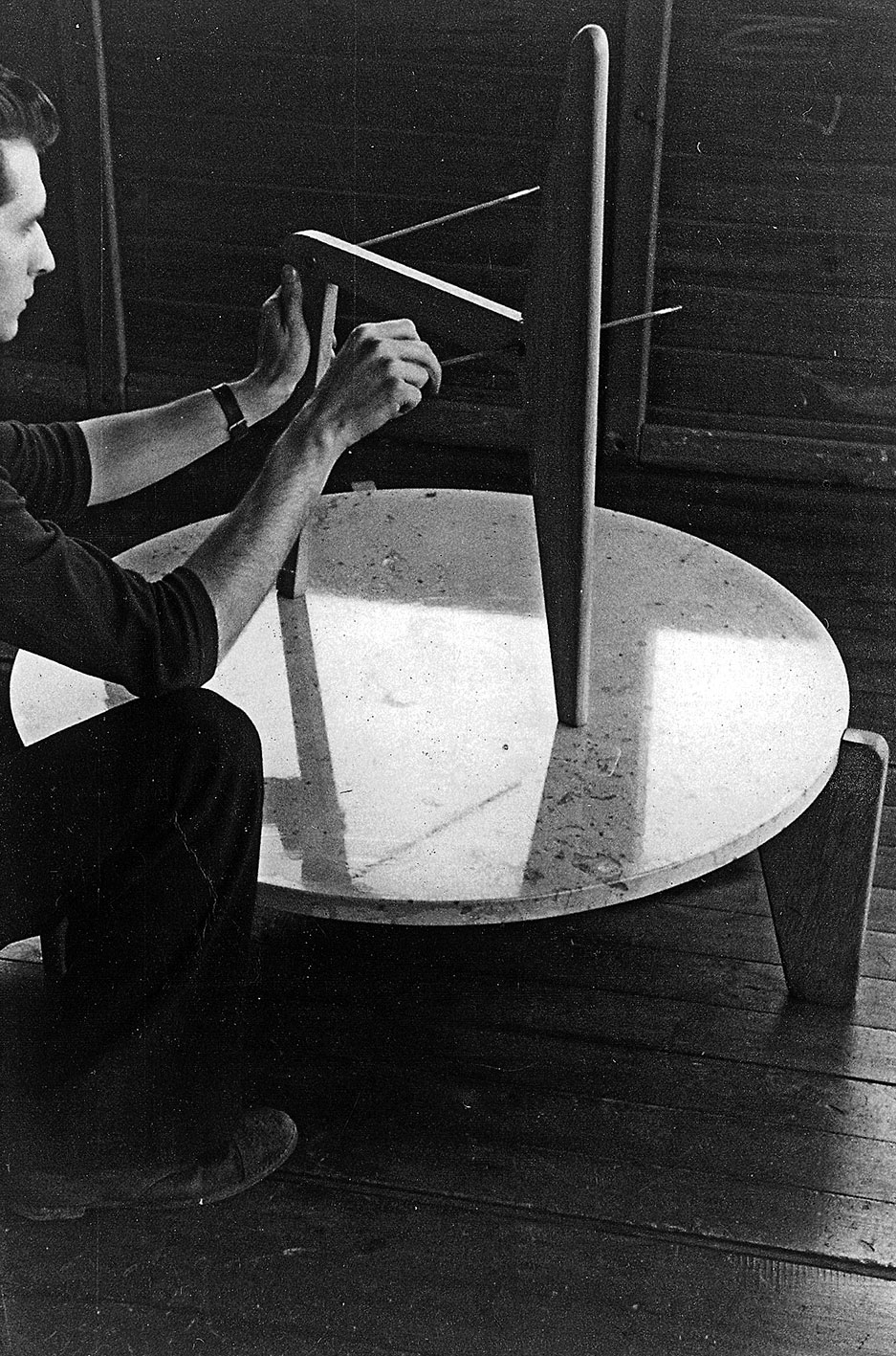 Demountable wooden chair CB 22. Demonstration of assemblage by André Le Stang, employee of the Ateliers Jean Prouvé in Jean Prouvé’s office in Maxéville, c. 1949.
