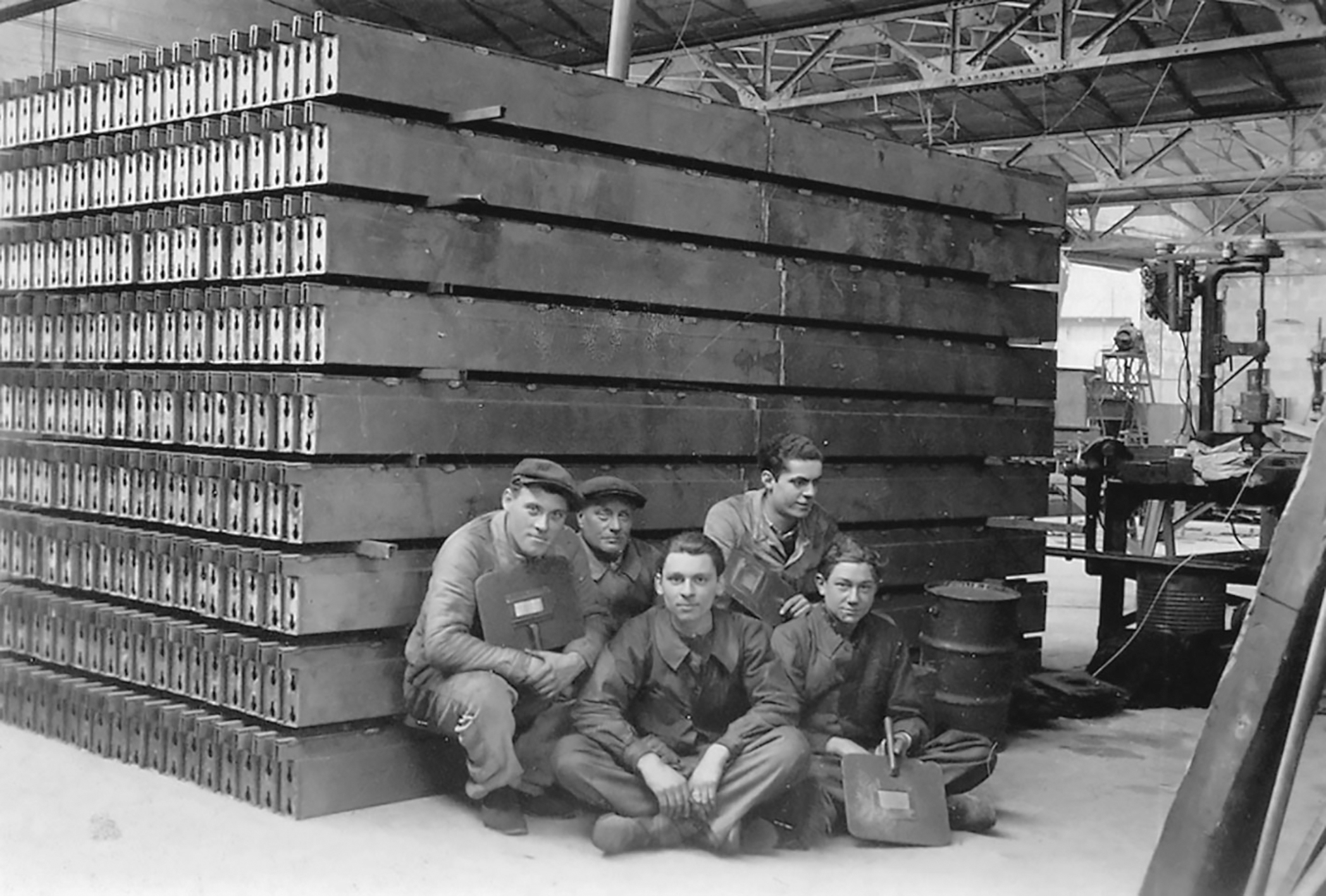 Groupe d’ouvriers posant devant les éléments de l’ossature des baraques militaires, 1939.