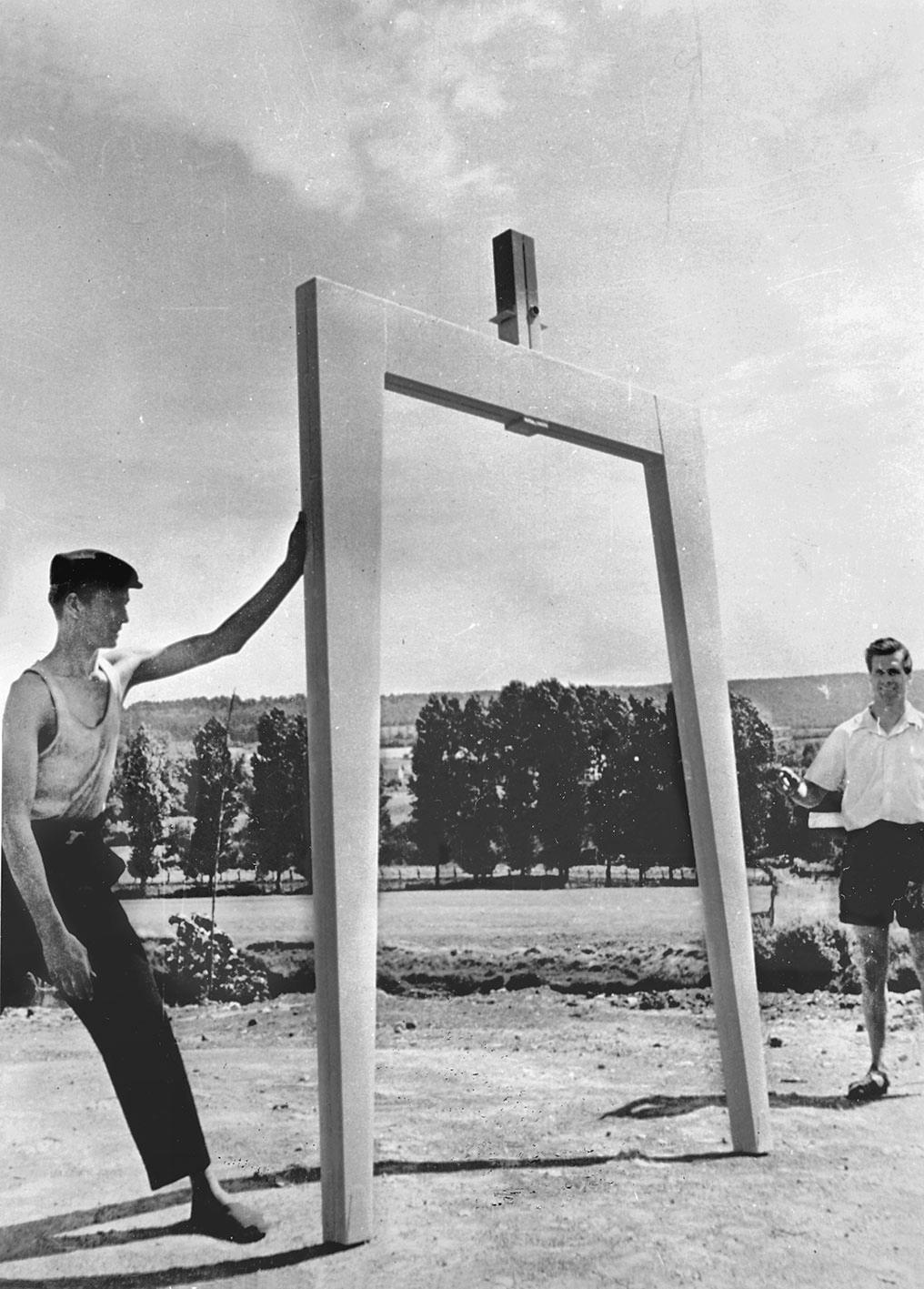 Pierre Prouvé and a colleague show the components of the Métropole houses: inverted U axial portal frame with central square-section swivel, c. 1950.