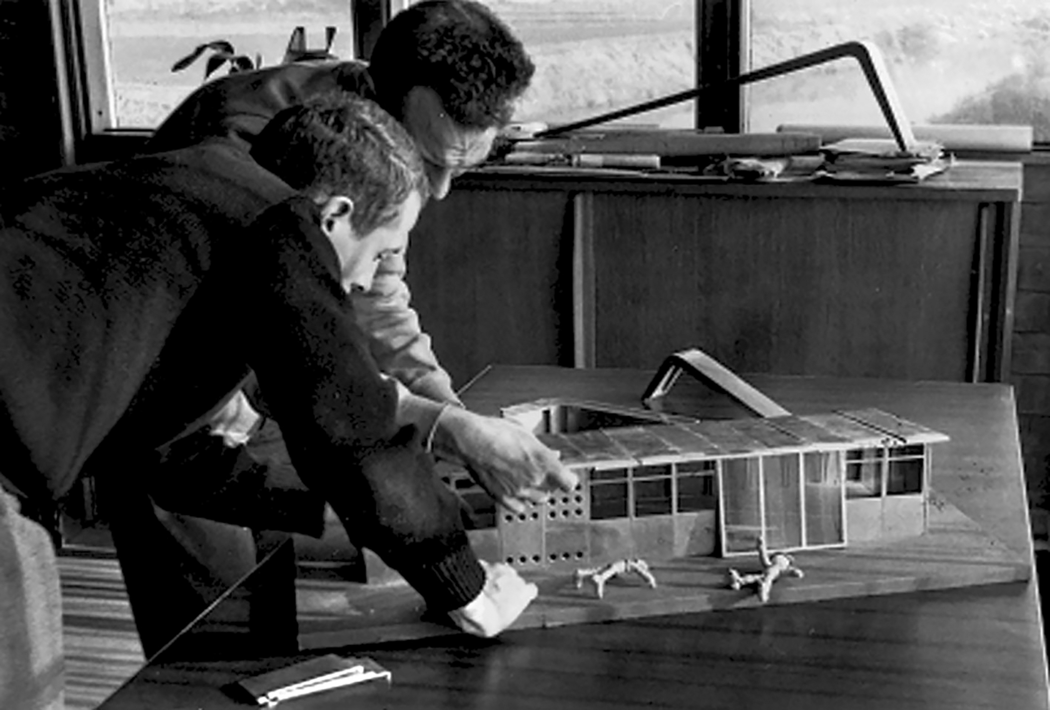 Maison linéaire. Henri Nardin et Pierre Oudot, architectes stagiaires aux Ateliers Jean Prouvé. Présentation de la maquette dans le bureau de Jean Prouvé, 1951.
