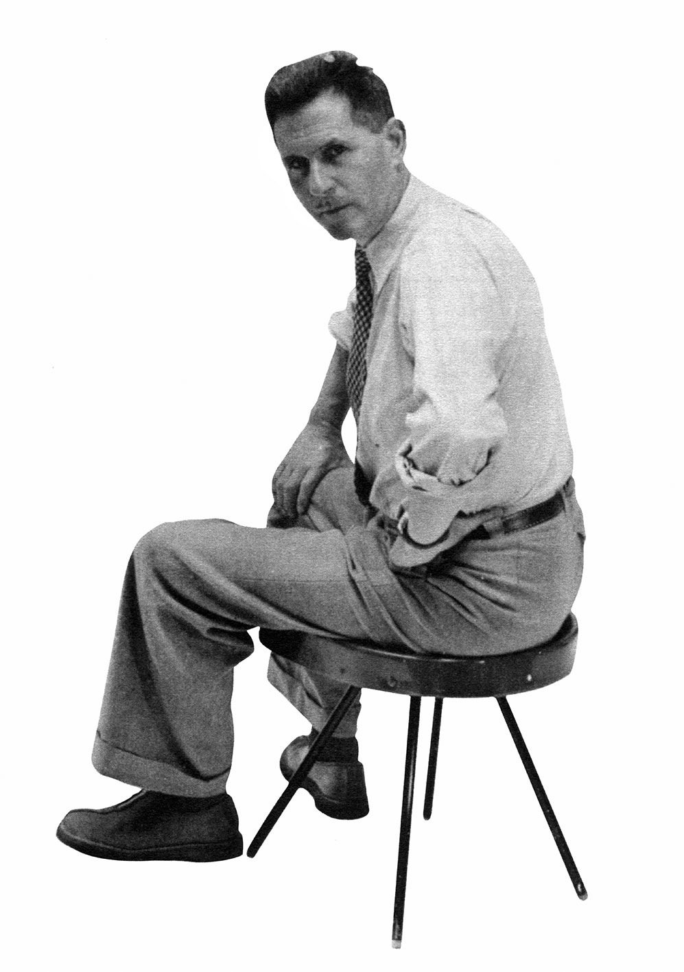 Jean Prouvé seated on a stool no. 307, ca. 1952.