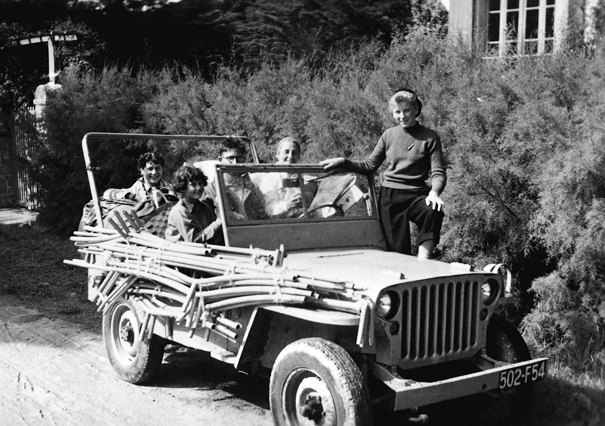 The Prouvé family on holiday with the frame of the “Papillon” (Butterfly) tent strapped to a jeep, ca. 1950.