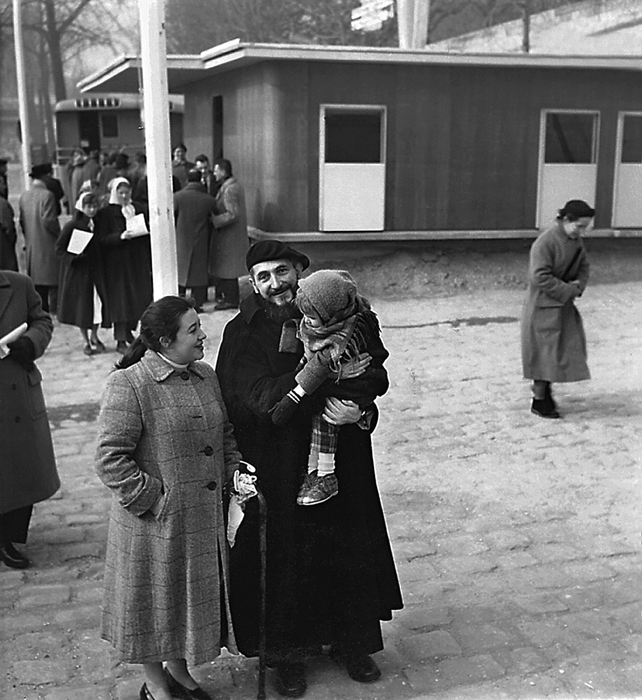 L’abbé Pierre en compagnie de la famille à laquelle la maison Les Jours Meilleurs est destinée, quai Alexandre-III, Paris, février 1956.