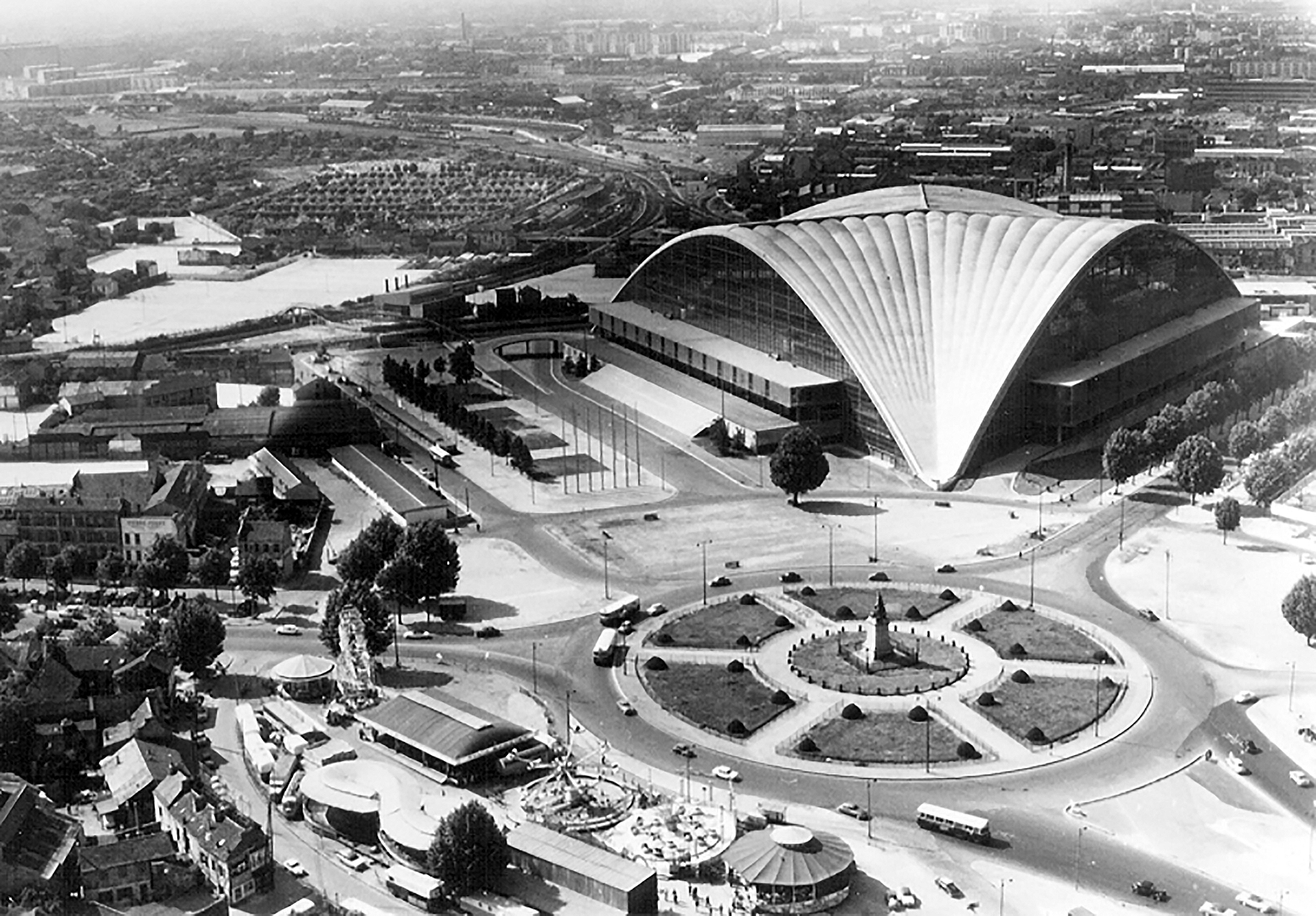 C.N.I.T., Centre National des Industries et des Techniques, Paris-La Défense, 1956–1958 (architects R. Camelot, J. de Mailly and B. H. Zehrfuss). In the center of the traffic circle, a statue "La Défense de Paris, 1871", which will give its name to the future business district.
