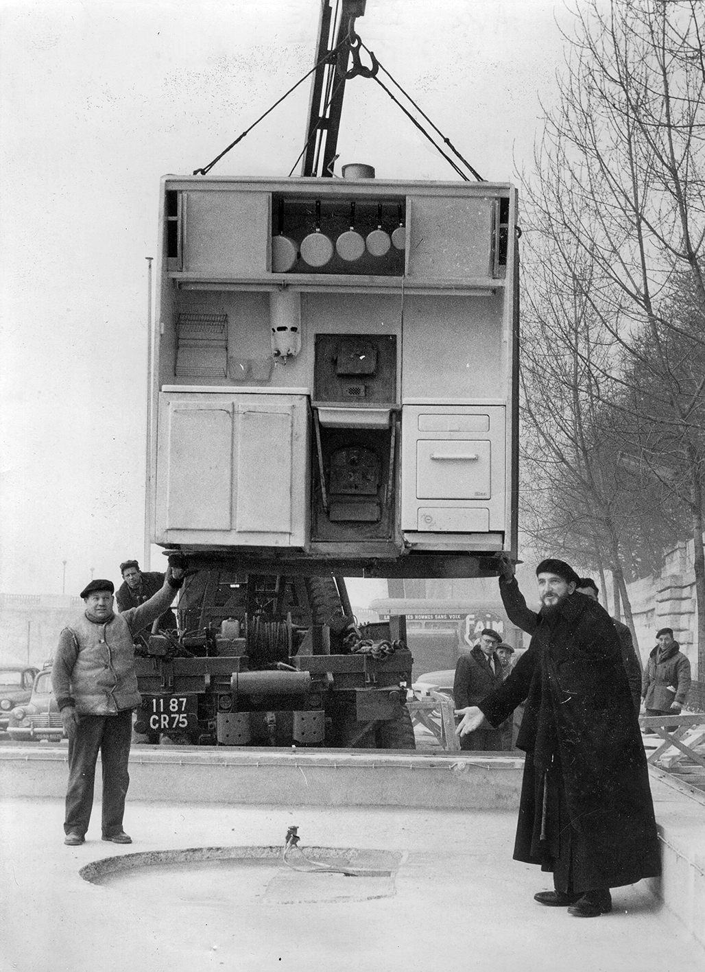Maison démontable Les Jours Meilleurs. L’abbé Pierre lors de l’installation du bloc central, quai Alexandre-III, Paris, février 1956.