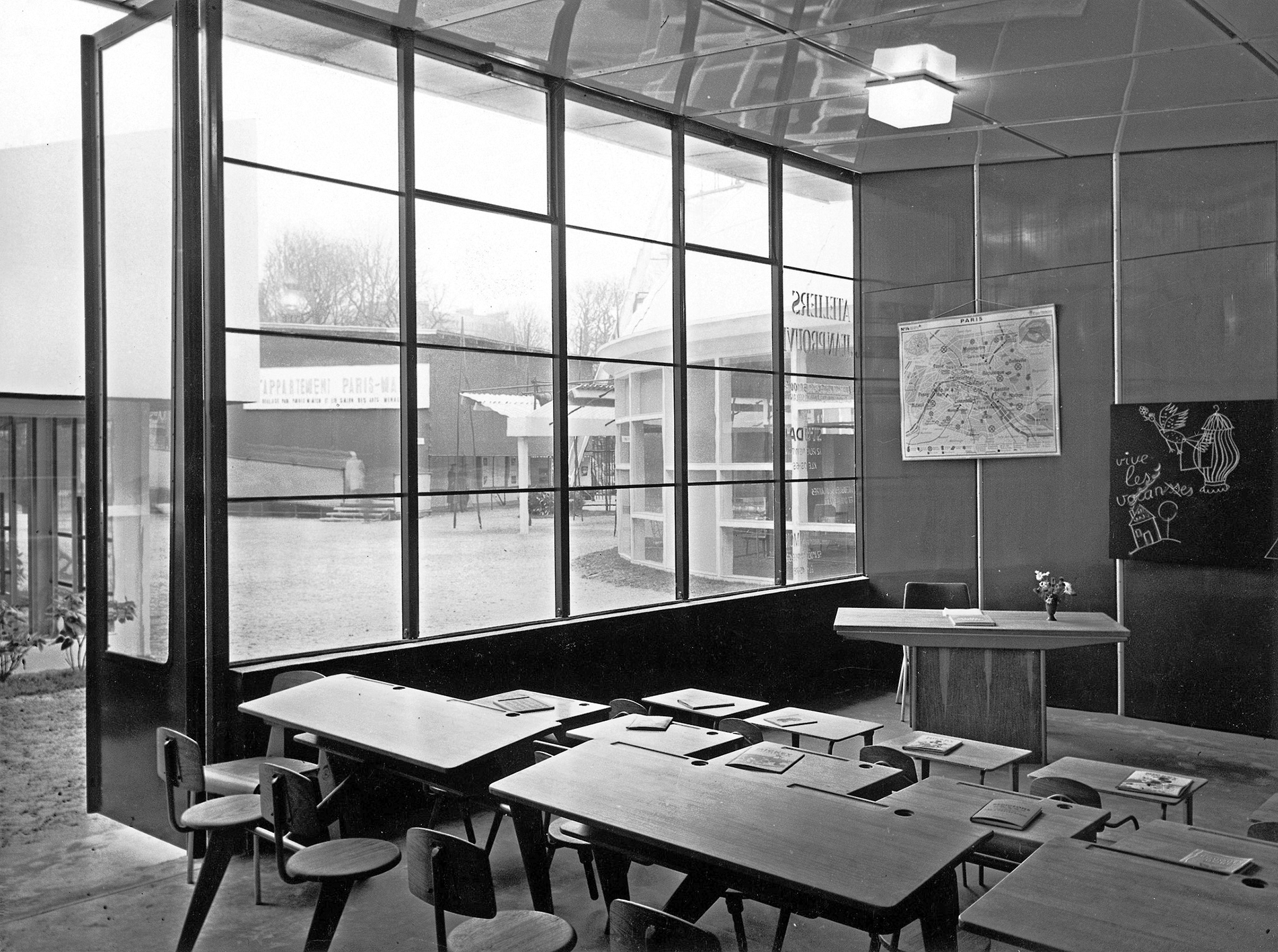Salon des Arts Ménagers home show, Housing section, Paris, 1952. The Ateliers Jean Prouvé stand. Classroom equipped with two-seater school desks PP 11, Ensembles Maternelle, and Standard Desk BS.